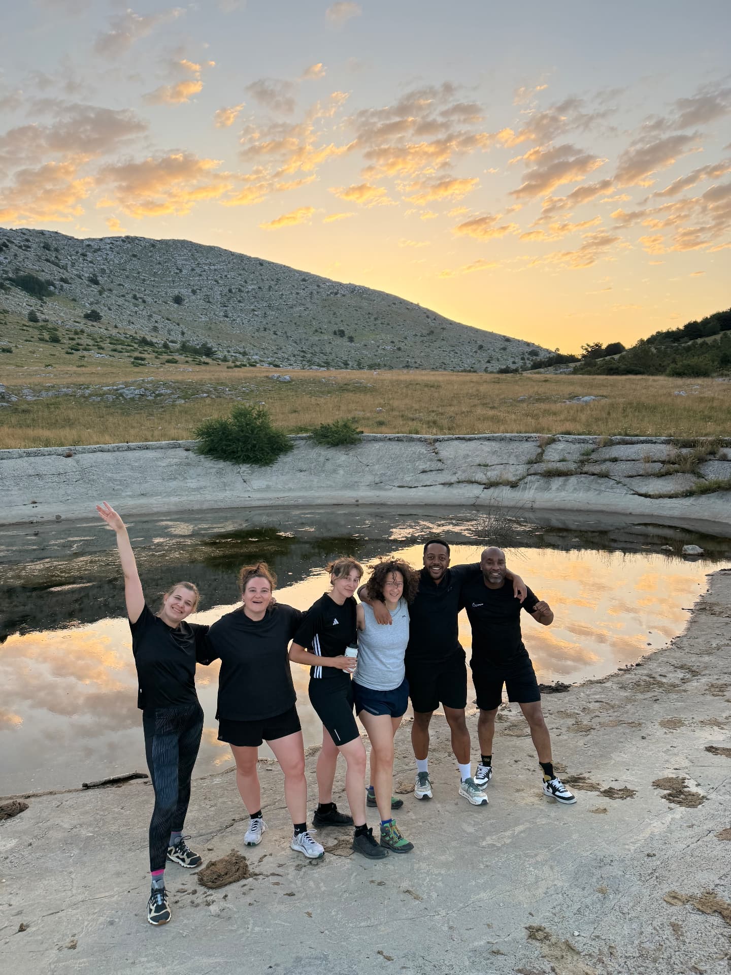 The group at a mountain pond at sunrise after the dark hike