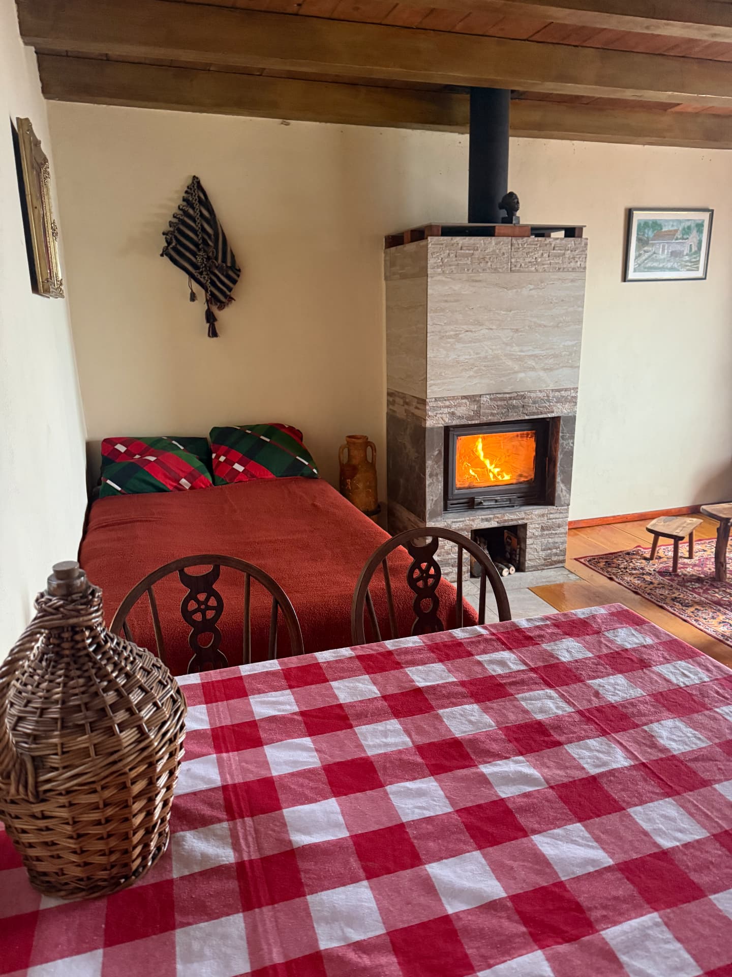 Wood stove burning beside the checkered dining table inside the house