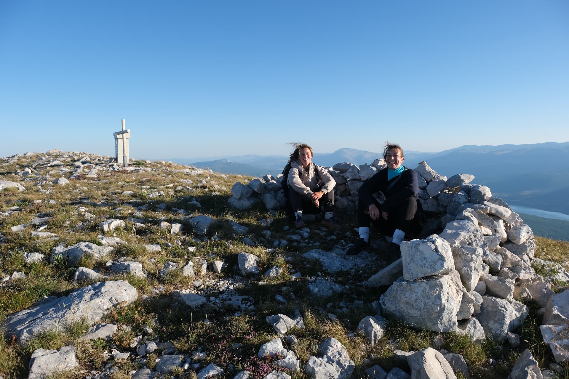 Two hikers resting in the stone shelter at the summit after the ridge hike