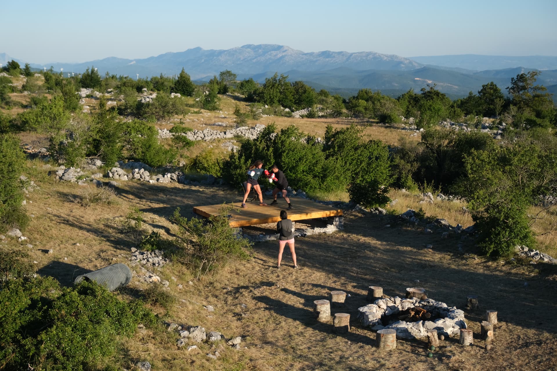 The stone fire circle, log seats and the wooden training deck on the rocky ridge