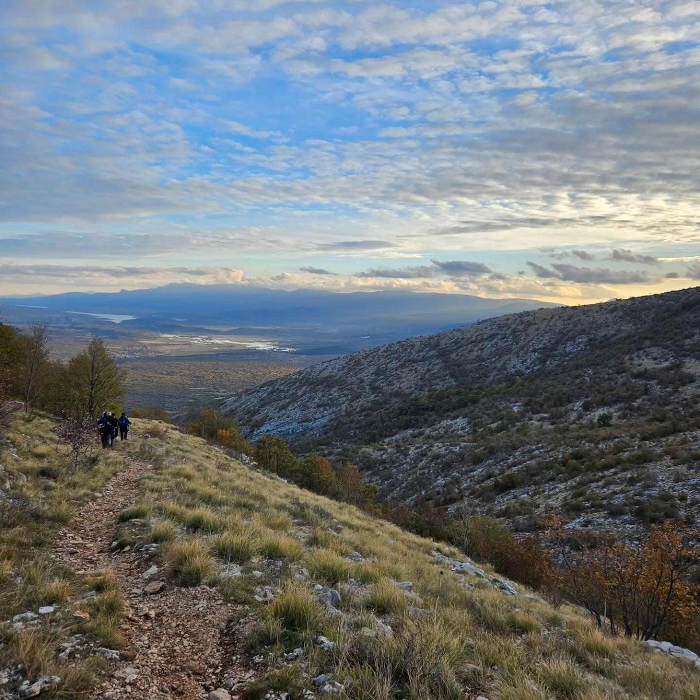 Two hikers on the trail above the valley at first light
