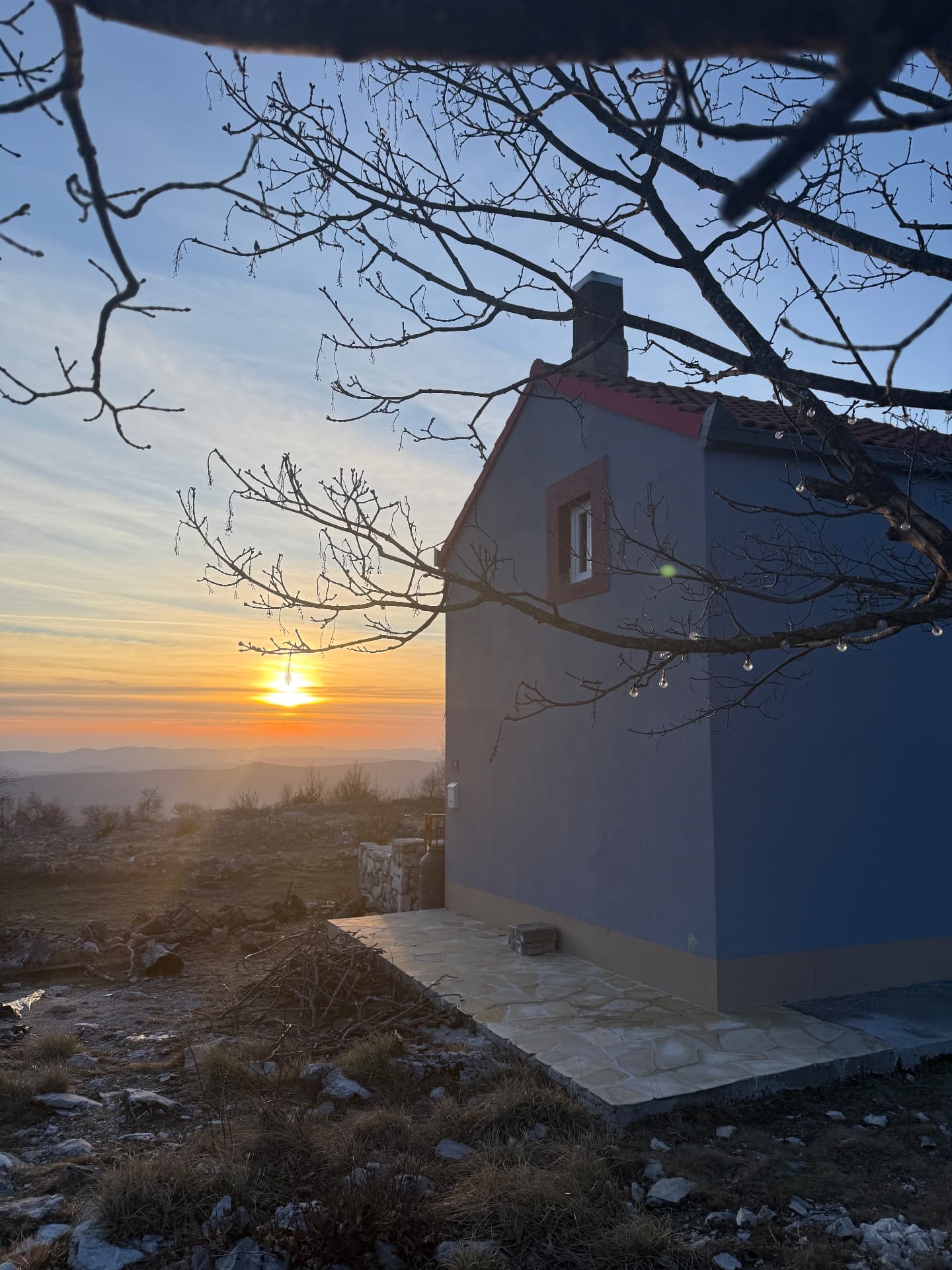 The house and the meadow against the evening sky